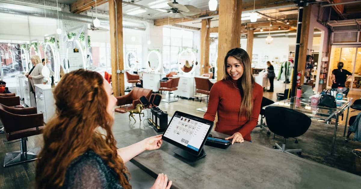 Two professionals reviewing charts and a laptop at a table, representing collaborative household financial and insurance planning.
