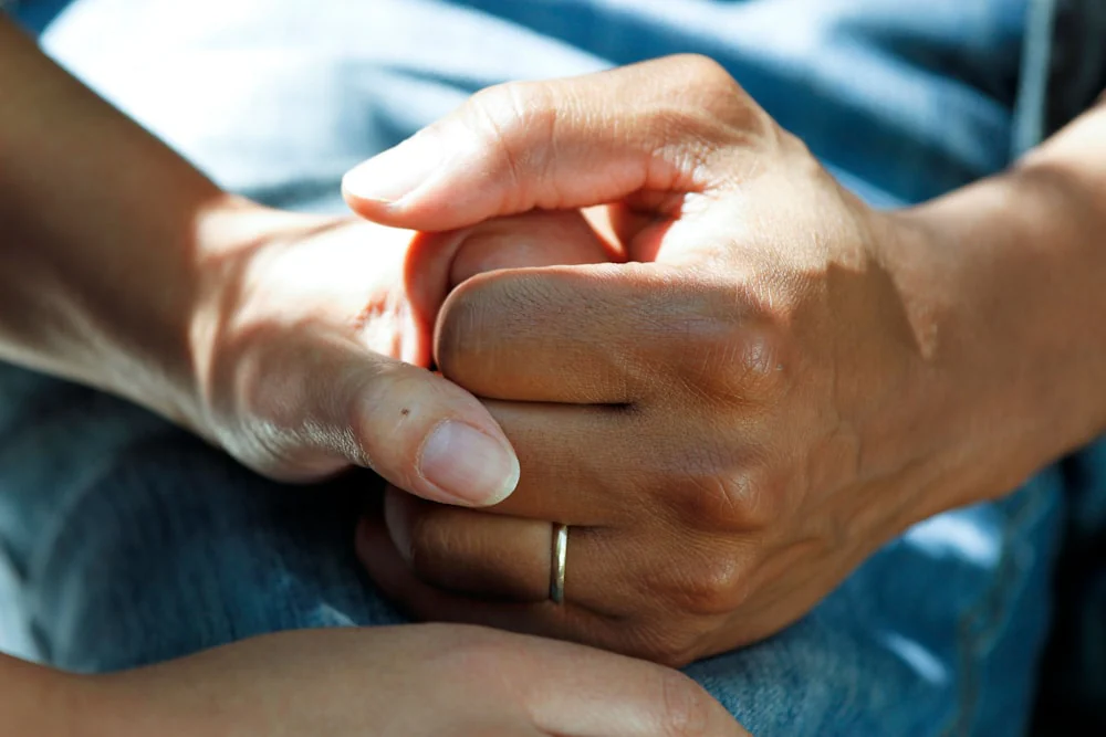 Two people talking with a health professional in a comfortable clinic setting