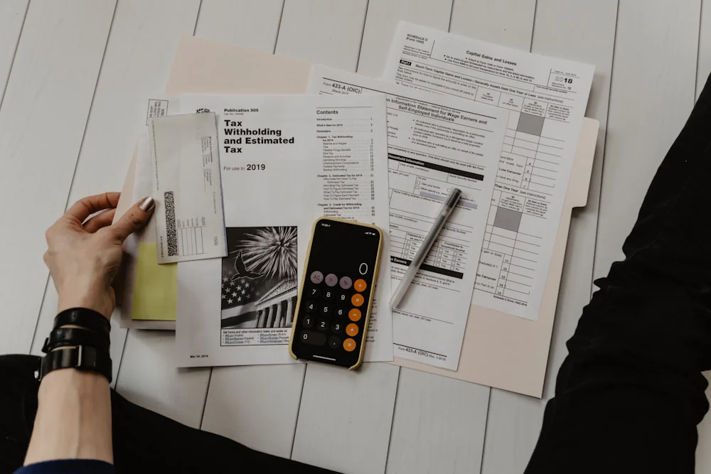 Person reviewing invoices and a calculator on a desk, representing budgeting for Medicare Advantage premiums, copays, and MOOP.